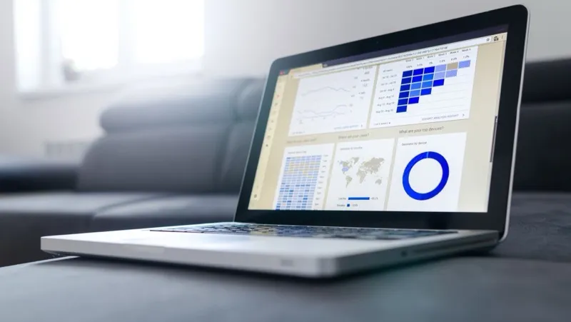 A laptop showing a Google Analytics dashboard with user, location and device reports